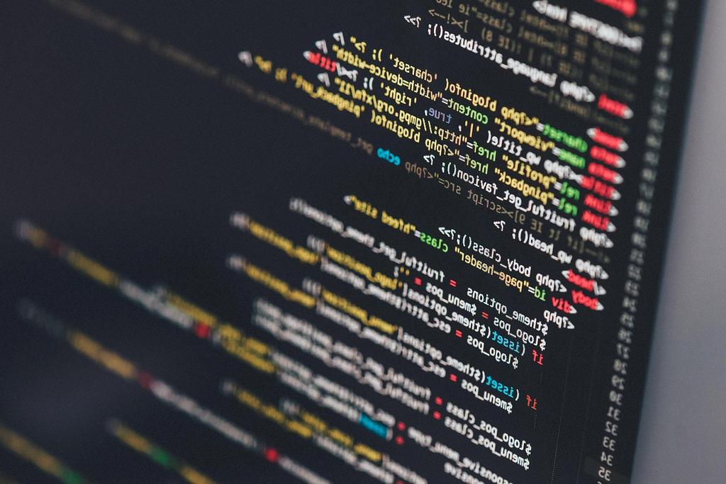 Developer coding on laptop with multiple screens displaying code and debugging tools